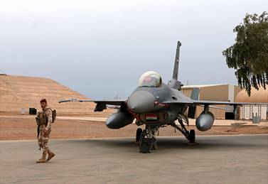 An Iraqi army soldier stands guard near a US-made Iraqi Air Force F-16 fighter jet at Balad airbase. AP