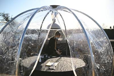 An employee sets a table in a dome on the terrace of a restaurant in Chester, north-west England. AFP