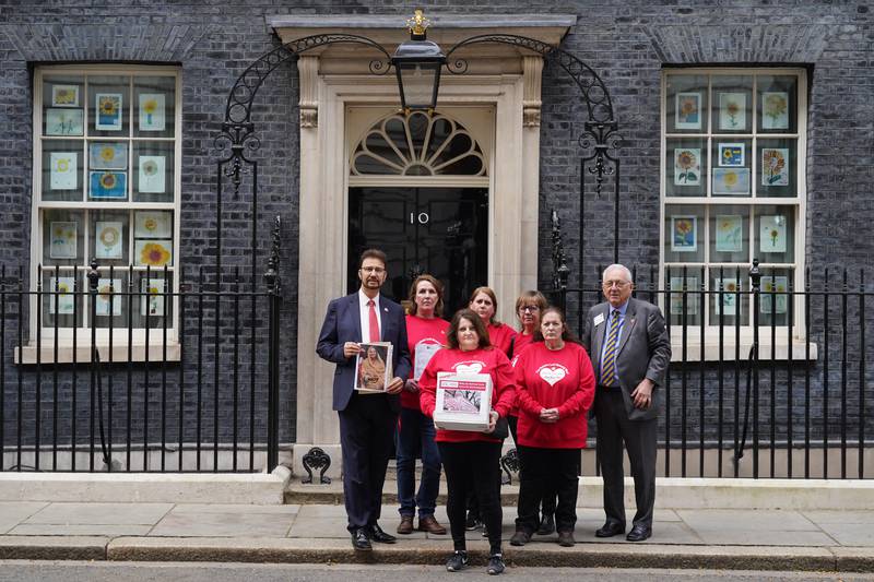 Families with MPs Sir Peter Bottomley, right, and Afzal Khan, left, deliver a petition to 10 Downing Street. PA