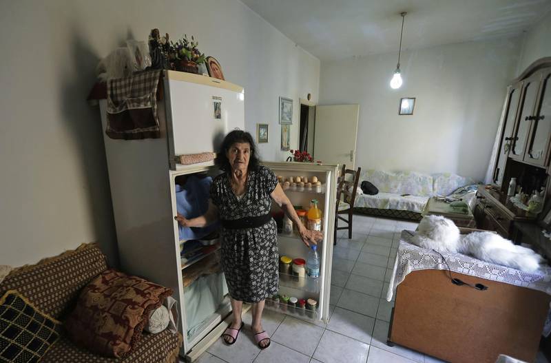 A Lebanese woman in Bouar north of Beirut displays the content of her refrigerator. AFP
