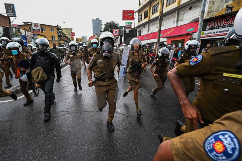 Policemen charge as university students and demonstrators protest against the Sri Lankan government and to demand the release of student leaders in Colombo. AFP
