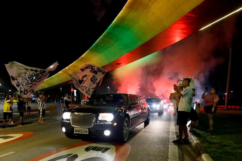 The hearse carrying Pele's coffin arrives in Santos as a firework goes off ahead of the football legend's funeral on January 2. Getty Images