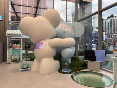 Giant hugging bears made of recycled materials greet customers at the entrance of the store. There are containers where people can place old or unused Samsung protective cases for recycling
