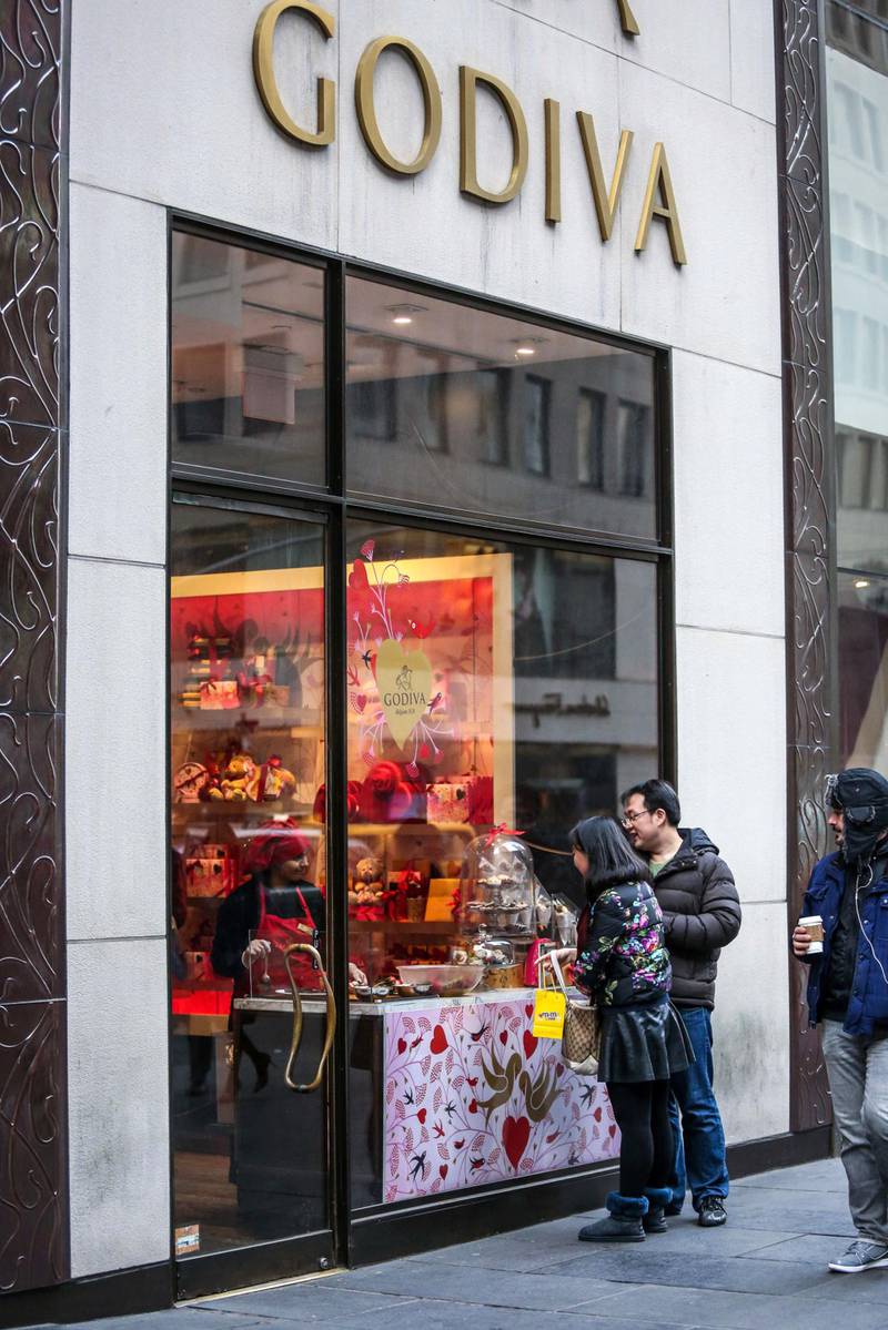 Pedestrians stop to look at a window display inside a Godiva Chocolatier Inc. store in New York, U.S., on Friday, Jan. 15, 2016. The New York-based private research group, the Conference Board, is scheduled to release its consumer confidence sentiment index on January 26. Photographer: Chris Goodney/Bloomberg