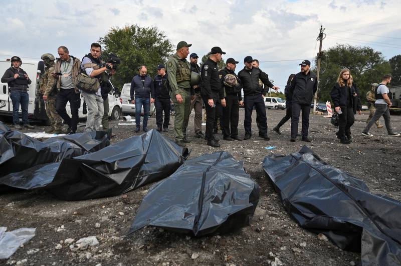 Ukrainian Interior Minister Denys Monastyrskyi stands next to the covered bodies of people killed in a Russian missile strike that hit a convoy of civilian vehicles. Reuters