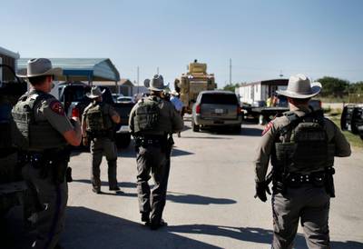 Texas State Troopers advance upon the scene at the bar Big Daddy Zane's near Odessa, Texas, where the Ector County Sheriff's Office made the arrest of eight individuals including the bar owner. AP