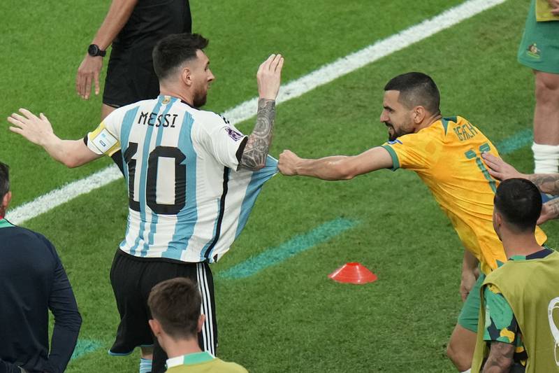 Australia's Aziz Behicc pulls the shirt of Lionel Messi. AP