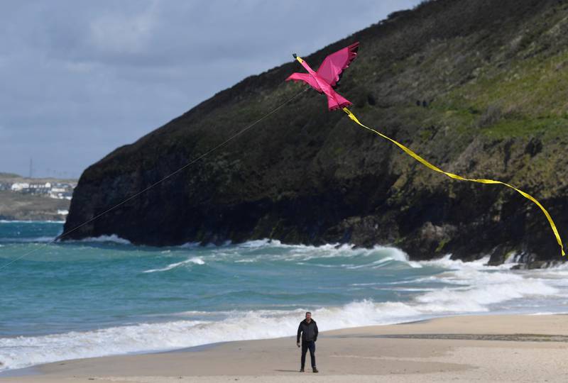 A man views a kite being flown on the beach at Carbis Bay. Reuters