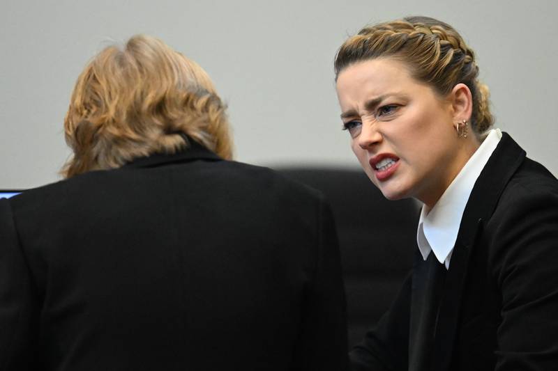 Amber Heard speaks with her lawyer. AP