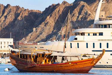 A traditional boat is moored next to a modern yacht in the port of Mutrah in the Omani capital Muscat on September 18, 2020. AFP