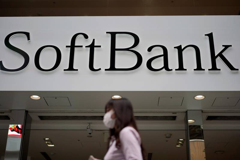 In this Oct. 8, 2019 photo, a person walks by a SoftBank shop in Tokyo. Japanese technology company SoftBank Group Corp. racked up a loss of 961.6 billion yen ($9 billion) for the fiscal year through March, on red ink related to its Vision Fund investments, including troubled office space-sharing venture WeWork. (AP Photo/Eugene Hoshiko)