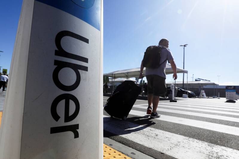 A passenger walks near Uber signage after arriving at Los Angeles International Airport (LAX) in Los Angeles, California. Reuters