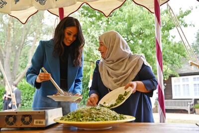 Meghan helps to prepare food at an event to mark the launch of a cookbook with recipes from a group of women affected by the Grenfell Tower fire, at Kensington Palace, in September 2018. Getty Images
