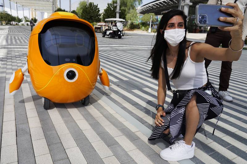 A visitor takes a selfie with a wandering robot. AP Photo