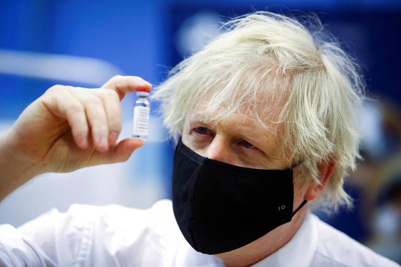 Britain's Prime Minister Boris Johnson holds a vial of an Oxford-AstraZeneca vaccine, during his visit to a vaccination centre at Cwmbran Stadium in south Wales. Reuters