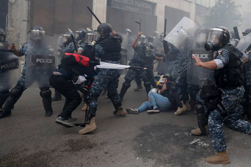 Riot policemen beat anti-government protesters near Parliament Square. AP