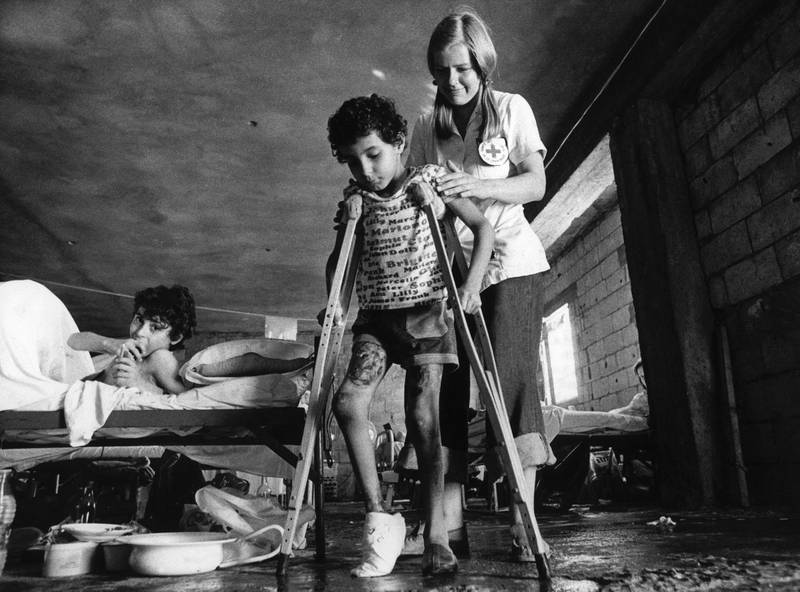 A Red Cross nurse from Sweden takes care 09 September 1976 at the Cross hospital located in the Coral Beach hotel on the road between Beirut and Saida of a boy shot in the heel by a sniper.The Lebanese civil war erupted in April 1975. (Photo by ERICH STERING / SCANPIX SWEDEN / AFP)