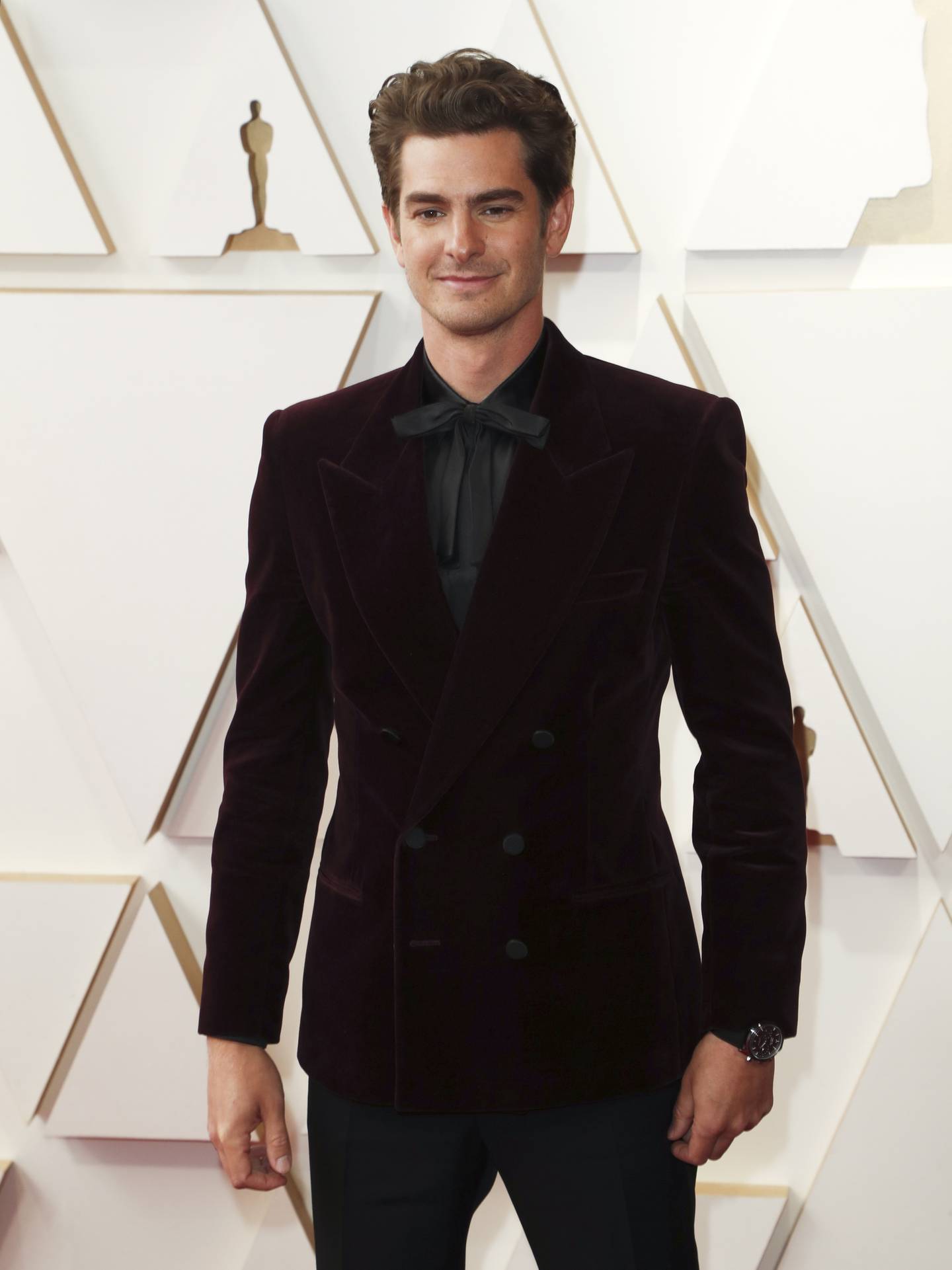 Andrew Garfield wears a black shirt under his burgundy velvet Saint Laurent tuxedo at the 94th annual Academy Awards on March 27, 2022. EPA