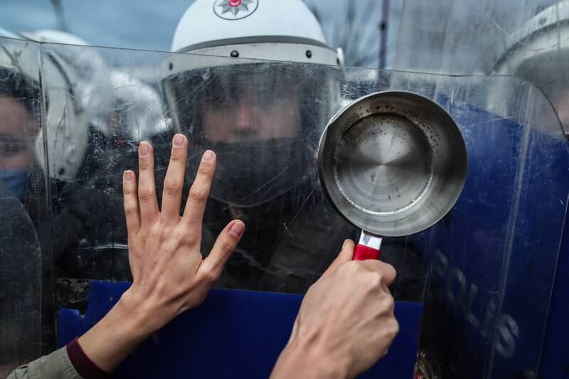 A female protester holding a pan tries to cross a police barricade during a demonstration against high bills and economic troubles in Istanbul, Turkey. EPA