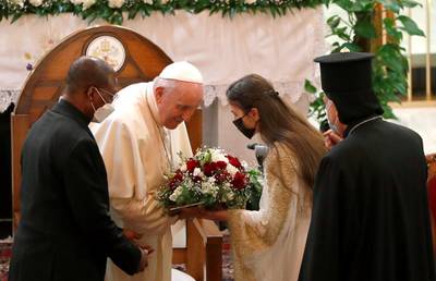 Pope Francis receives flowers are he arrives at the Our Lady of Salvation Church. Reuters