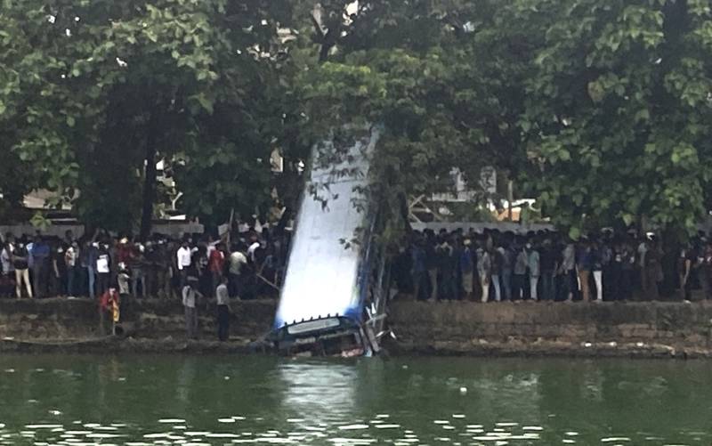 Sri Lankans push a bus, transporting government supporters who attacked anti-government protesters, into a lake in Colombo. AP Photo