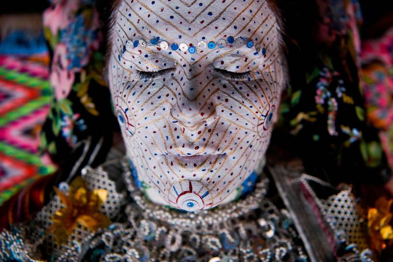 Kosovar woman Sheqerie Buqaj lays on her back as she receives a traditional face painting for a wedding of Bosnian women from the Zhupa region. Armend Nimani/AFP
