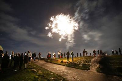 People on Calton Hill watch fireworks in Edinburgh. AP Photo
