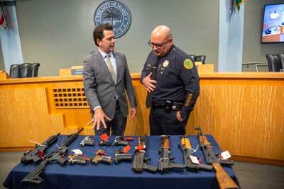 Miami District Two commissioner Ken Russell, left, and Miami police chief Manuel Morales with weapons collected in the Guns 4 Ukraine initiative, at Miami City Hall in Florida. Guns bought back by Miami will be delivered to sister city Irpin, near Kyiv. EPA