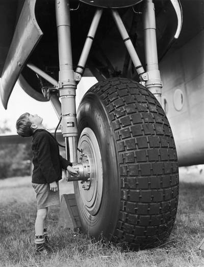 A young visitor stands by the wheel of an Avro York transport plane at Farnborough Airshow in 1950.