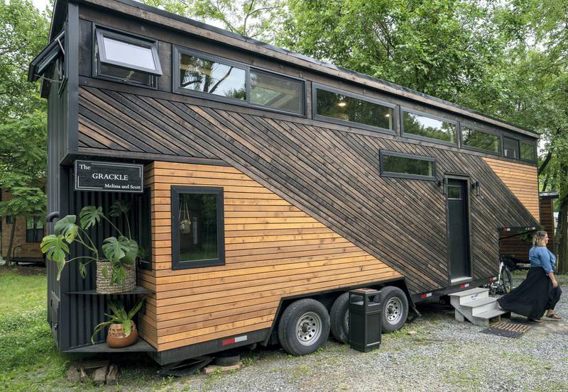 Melissa Meshey walks out of her tiny home called Grackle, built at Liberation Tiny Homes, on June 5, 2019 in Elizabethtown, Pennsylvania. - In a country where bigger is nearly always better -- think supersize fries, giant cars and 10-gallon hats -- more and more Americans are downsizing their living quarters.  Welcome to the world of tiny homes, most of them less than 430 square feet (40 square meters), which savvy buyers are snapping up for their minimalist appeal and much smaller carbon footprints. (Photo by Don Emmert / AFP)