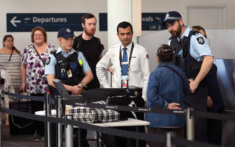 Police help screen passengers at Sydney Airport on July 30, 2017.
Australia has foiled an Islamist-inspired "terrorist plot" to bring down an airplane with an improvised explosive, authorities said on July 30, after four people were arrested in raids across Sydney. / AFP PHOTO / WILLIAM WEST