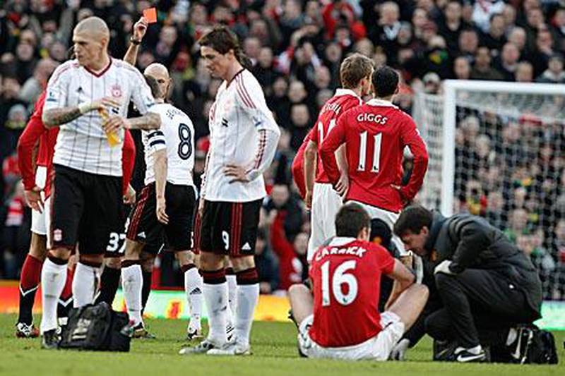 Steven Gerrard, No 8, is shown the red card by referee Howard Webb after a lunge on Manchester United's Michael Carrick.