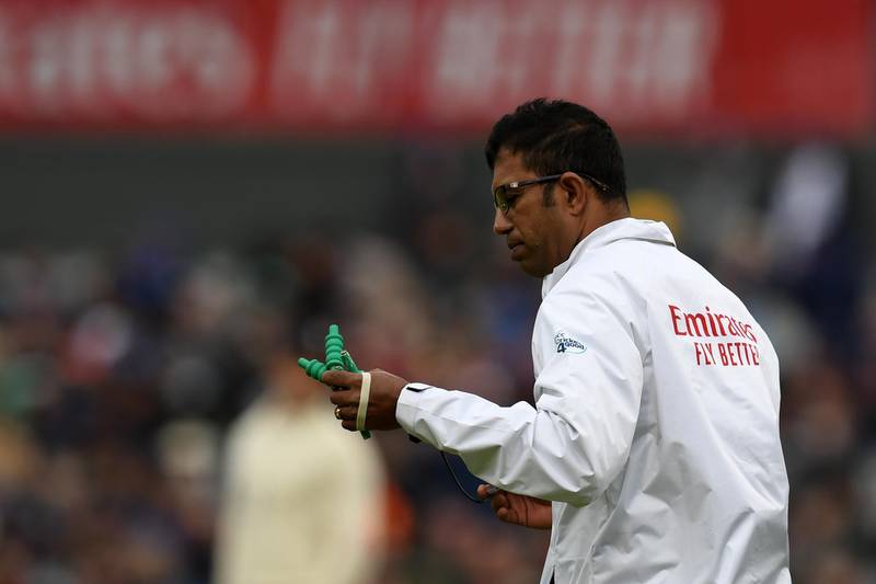 Umpire Kumar Dharmasena brings on heavier bails in windy conditions. AFP