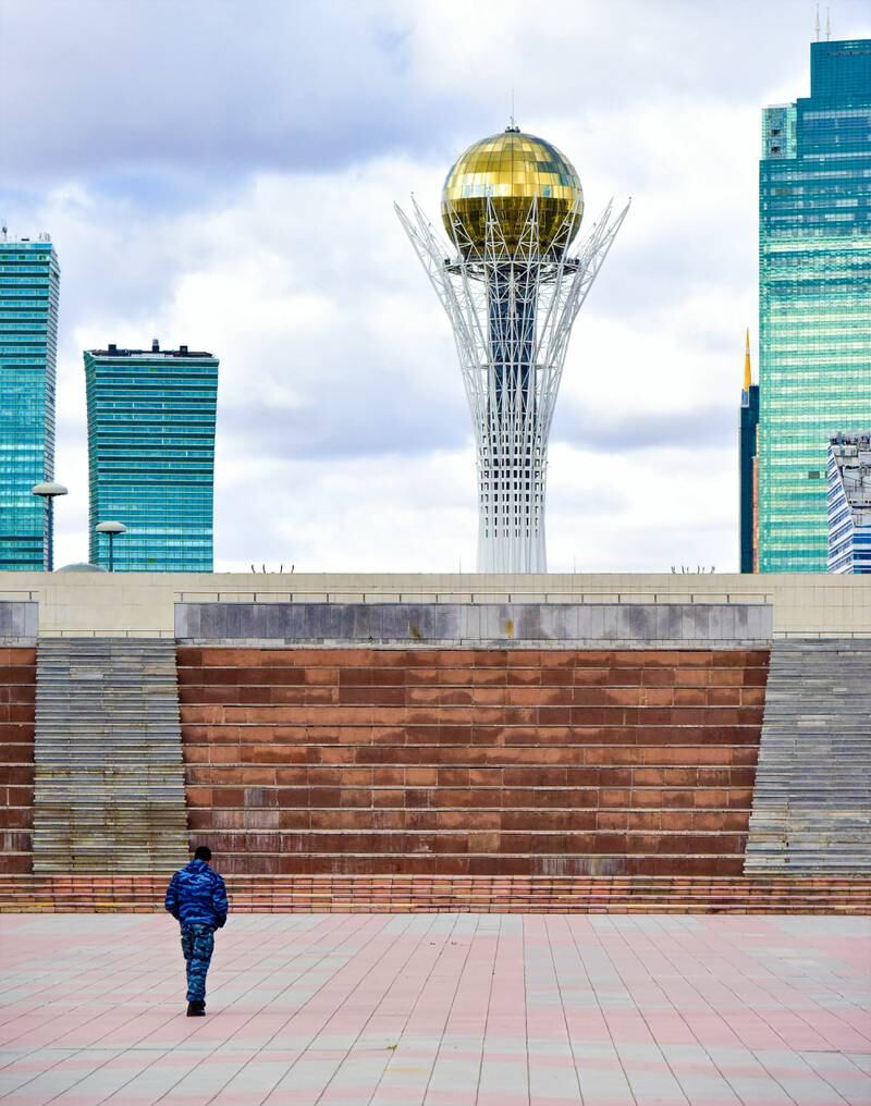 A soldier walks through an empty square between the presidential palace in Astana and the Baytarek Tower. Nick Walton