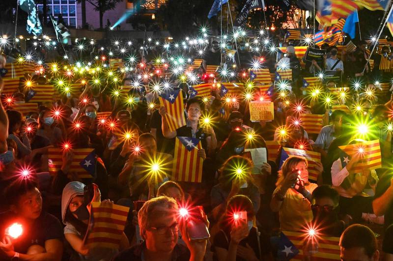 People hold Catalan pro-independence "Estelada" flags and light up their mobile phones during a Hong Kong-Catalonia solidarity assembly in Central district in Hong Kong, China. AFP