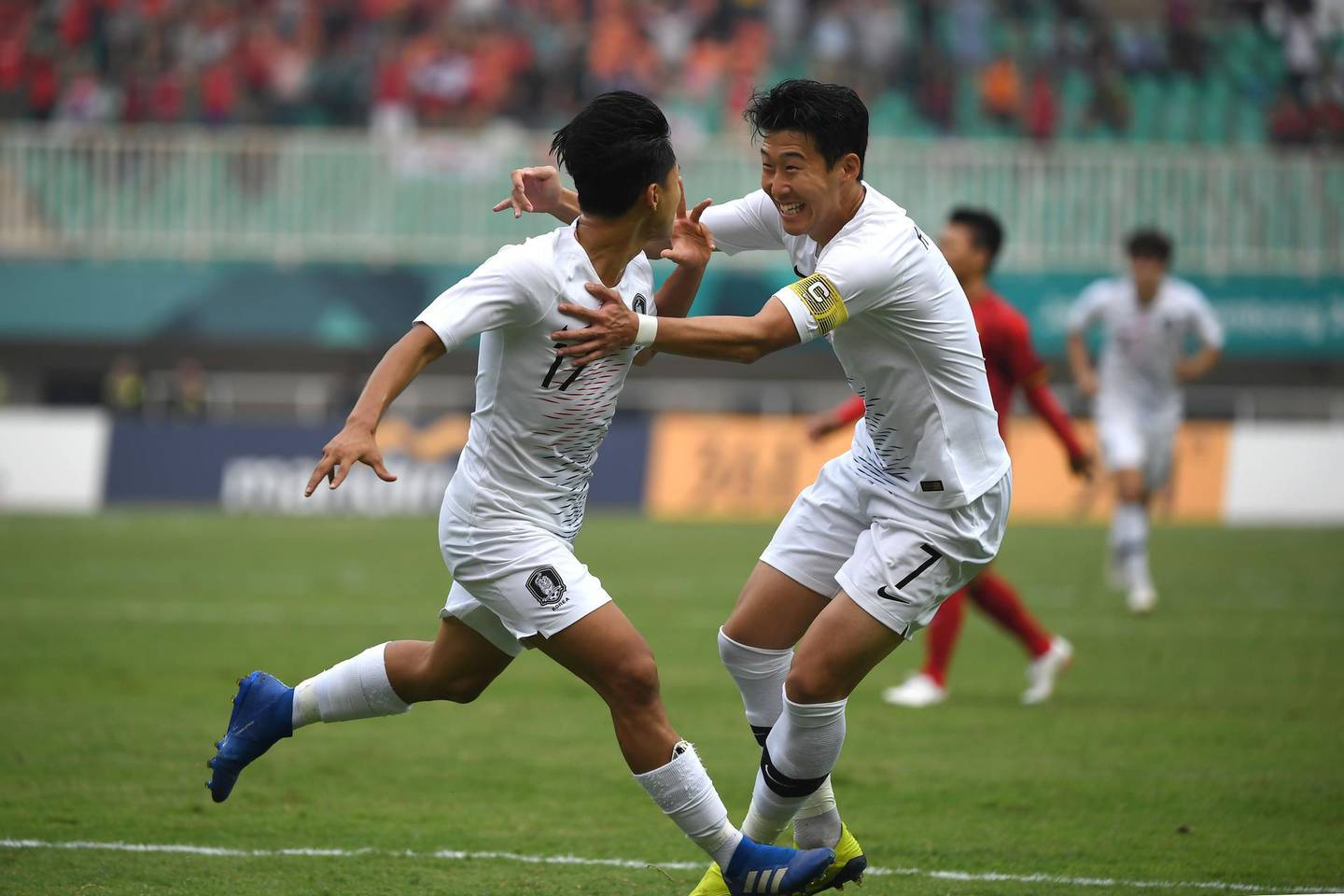 South Korea's Lee Seung-woo (L) celebrates with teammate Son Heung-min (R) after scoring during the men's football semi-final match between Vietnam and South Korea at the 2018 Asian Games in Bogor on August 29, 2018. (Photo by Arief Bagus / AFP)
