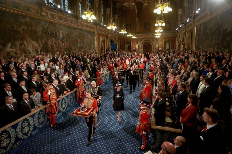 Britain's Prince Charles, the Duchess of Cornwall and Prince William follow the Imperial State Crown through the Royal Gallery for the State Opening of Parliament at the Palace of Westminster in London.  AP