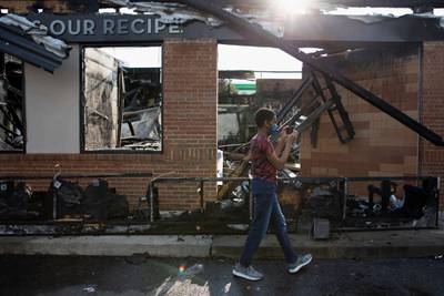 A boy films with his mobile phone at the site of a Wendy's restaurant set ablaze overnight in Atlanta, Georgia. Getty Images
