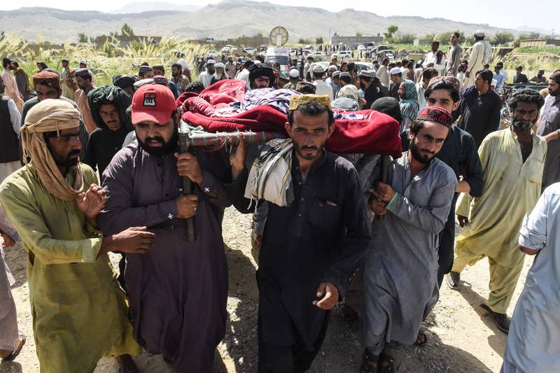 Residents carry the body of a victim for burial following an earthquake in the mountainous district of Harnai in south-west Pakistan. AFP