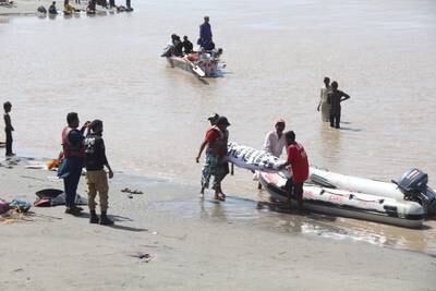 Edhi rescue workers search for bodies of flood victims who were washed away in the Indus river near Hyderabad, Sindh province. EPA