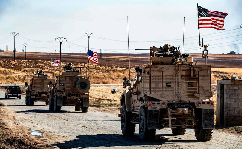 US military armoured vehicles drive in a patrol past an oil well in Rumaylan (Rmeilan) in Syria's northeastern Hasakeh province. AFP