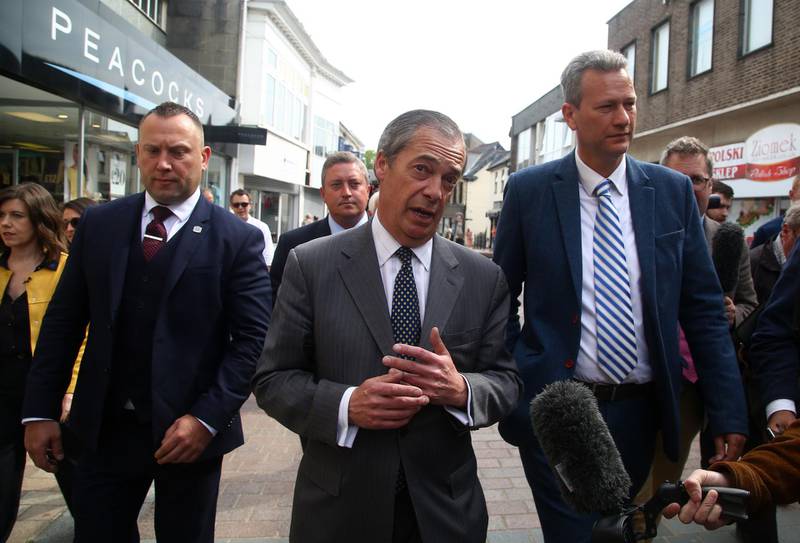 Brexit Party leader Nigel Farage (C) and Brexit Party MEP candidates for Wales, James Wells (3L) and Nathan Gill (centre R) attend a European Parliament election campaign rally at the Trago Mills car park in Merthyr Tydfil, south Wales on May 15, 2019.  / AFP / GEOFF CADDICK
