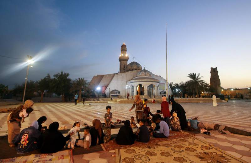 An Iraqi family break their fast at Imam Ali Mosque in Basra, south-east Iraq. Reuters