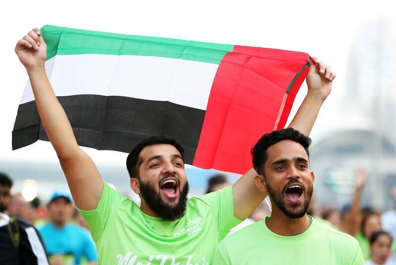 Participants proudly display the UAE flag during Dubai Run 2022