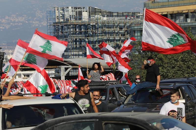 People wave Lebanese flags and chant to mark the first anniversary of anti-government protests.  Getty Images
