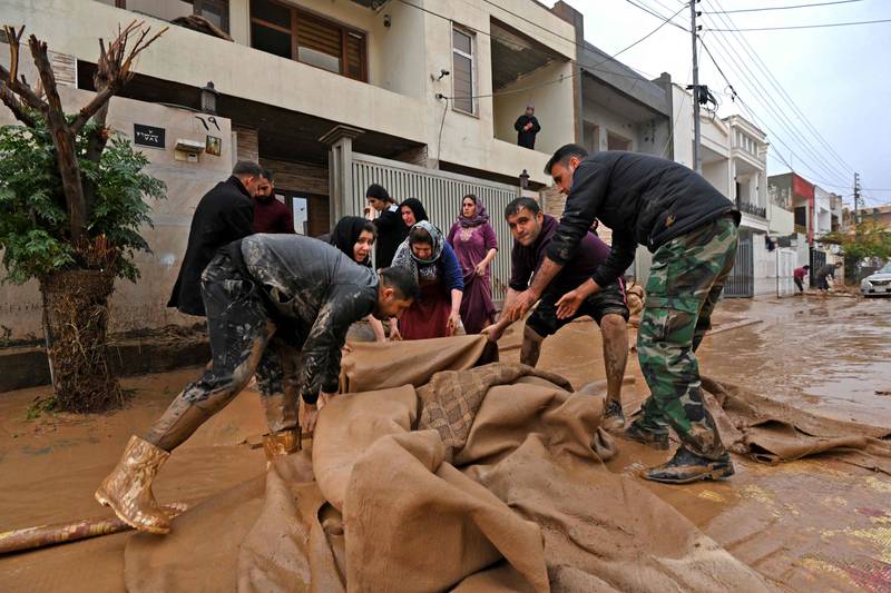 Residents try to salvage some belongings. Heavy rain fell on Thursday evening around Erbil.