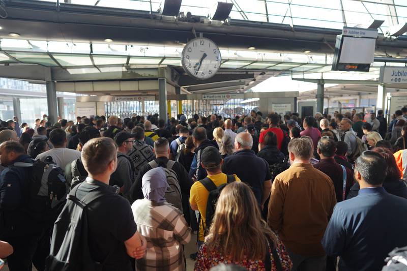 Passengers wait for Stratford station to open in London on Wednesday morning as train services continue to be disrupted following the nationwide strike by members of the Rail, Maritime and Transport union. PA
