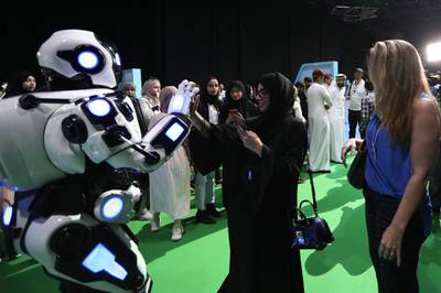 epa07920041 Visitors interact with a robot during Dubai Artificial Intelligence in Sports (DAIS) Conference and Exhibition in Dubai, UAE, 14 October 2019. Reports state the two-day event is bringing together leading figures from the sport and Artificial Intelligence (AI) arenas for discussions on integrating AI into sports industry.  EPA/ALI HAIDER