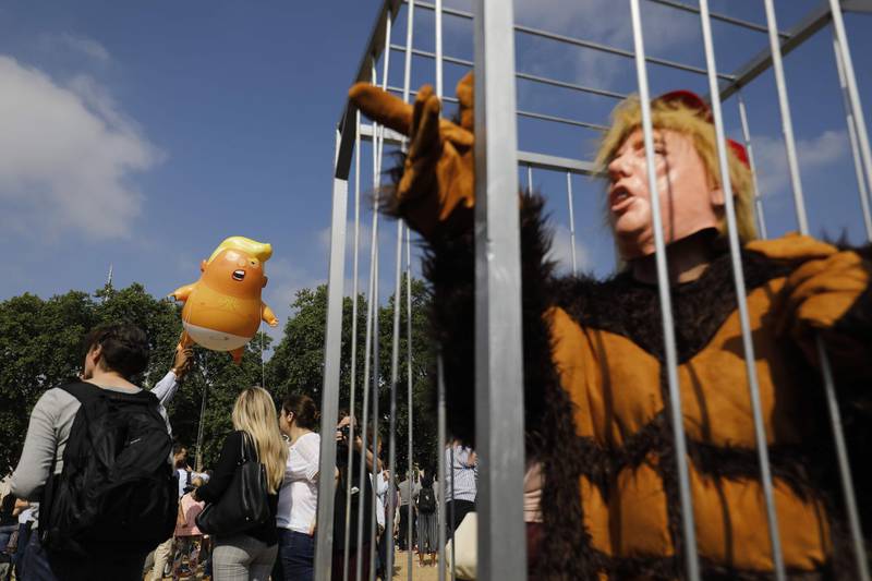 Protesters gather around a giant balloon depicting US president Donald Trump as a giant orange baby during a demonstration at Parliament Square in London, UK. AFP