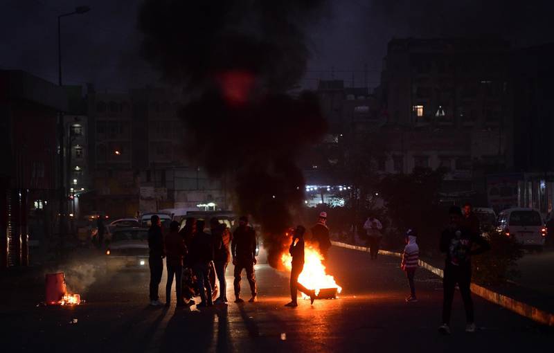 Iraqi protesters set fire to block a street during a strike and anti-government demonstrations at the Al-Tayaran Square in central Baghdad.  EPA